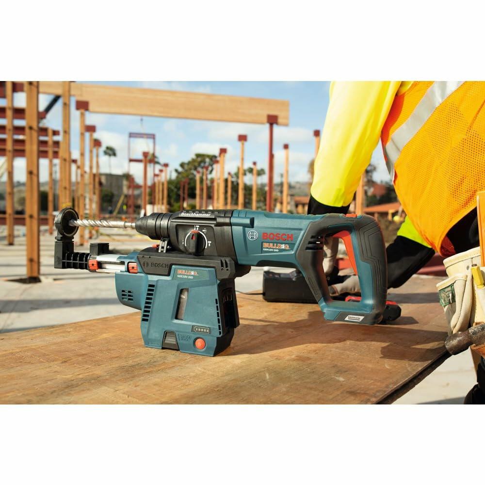 Bosch GBH18V-26 cordless rotary hammer drill on wooden surface at construction site; worker in safety gear visible in background.