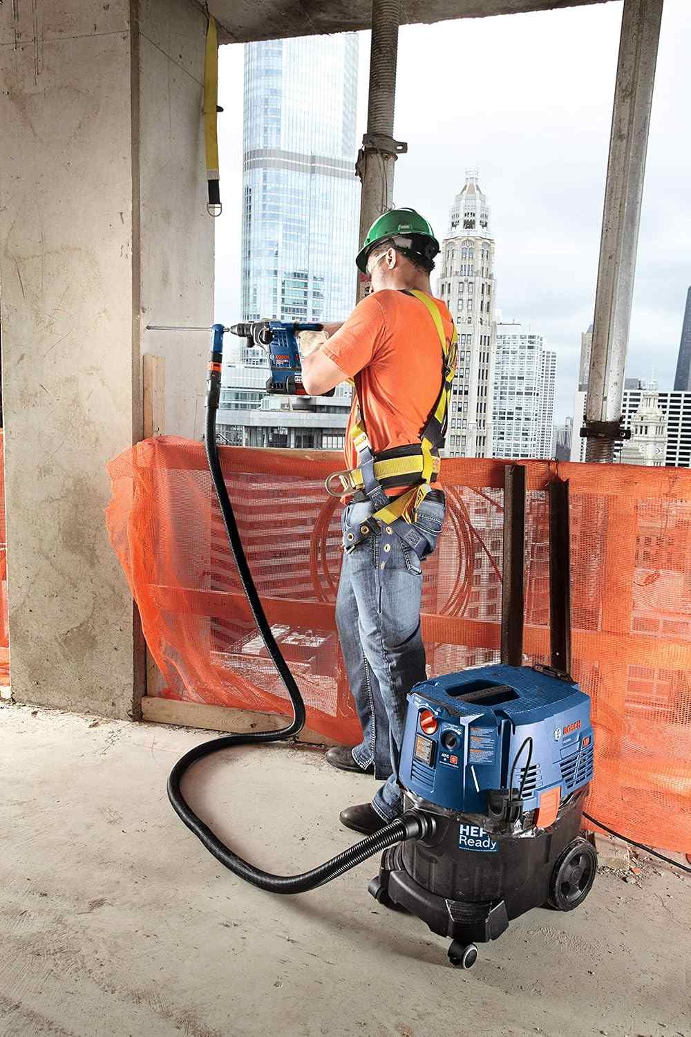 Action shot of a worker drilling into a concrete pillar with the bit connected to a Bosch HEPA Ready dust extractor.