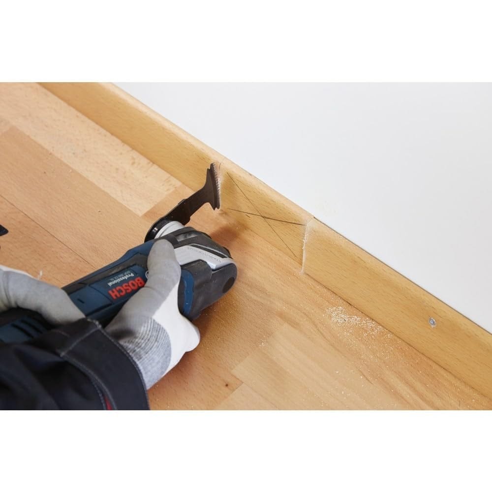 Close-up action shot of the Starlock blade performing a precise plunge cut into wooden baseboard molding.