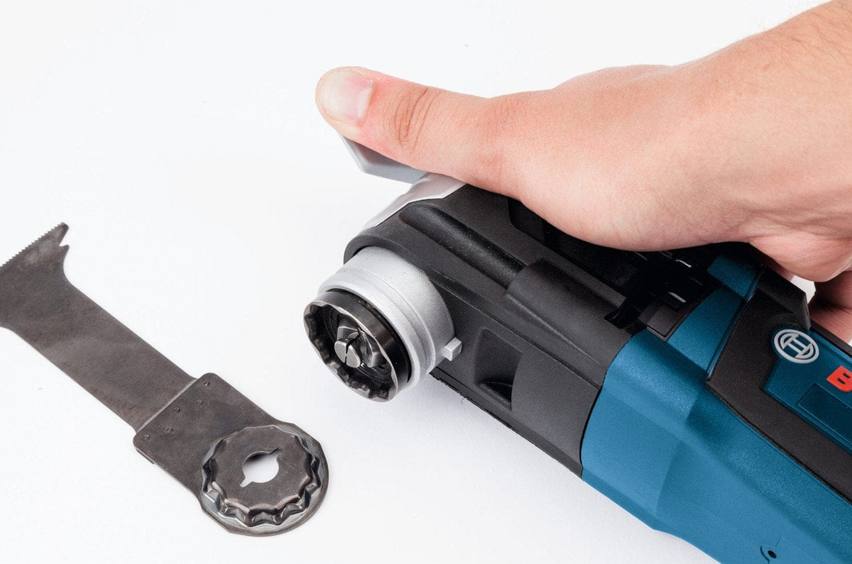 Close-up view of a Starlock blade being ejected from the multi-tool head using the quick release lever.