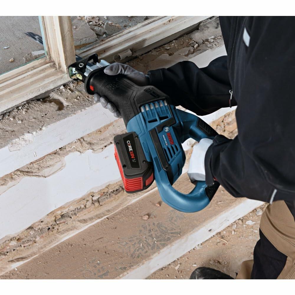 Individual using a Bosch cordless reciprocating saw with CORE18V battery to cut through an old window frame. The image showcases the tool’s precision and convenience for demolition work in tight spaces.