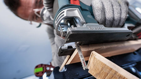An action shot of the Bosch T101BIF jig saw blade being used to make a precise cut in a laminate flooring plank, demonstrating the high level of control and clean finish.