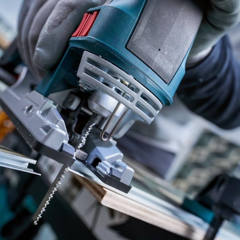 Close-up action shot of a blue Bosch jigsaw equipped with a T102H blade cutting through a thin white plastic sheet.
