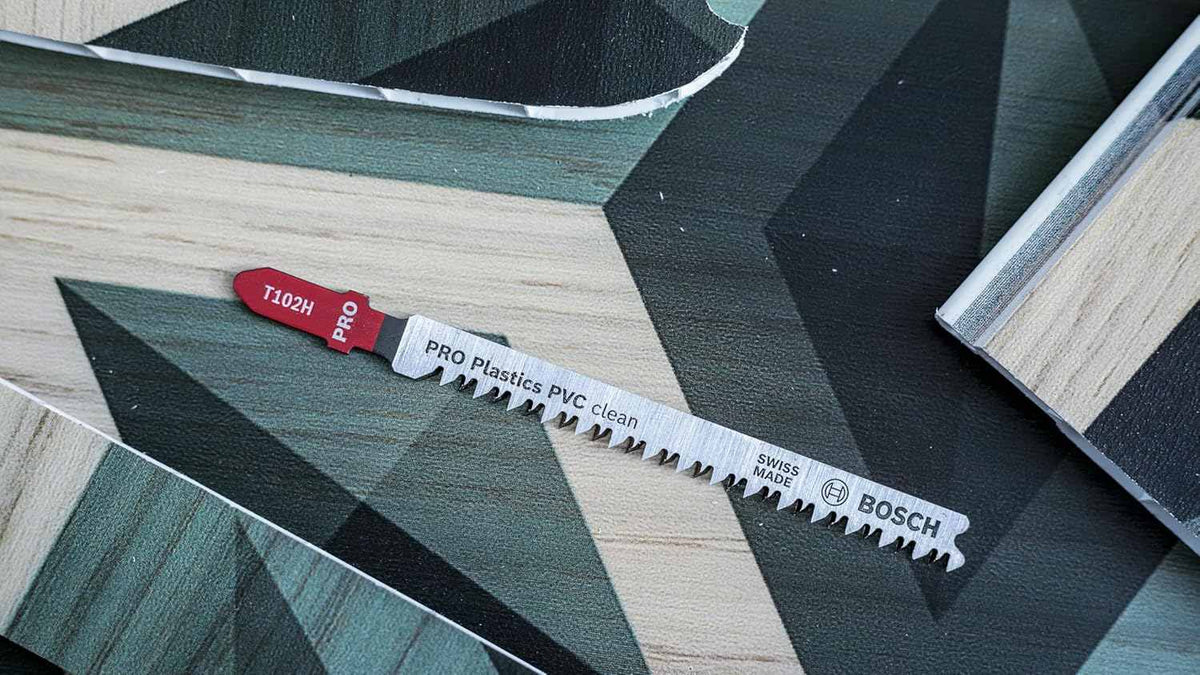 Overhead view of a Bosch T102H jigsaw blade resting on a patterned vinyl or laminate surface.