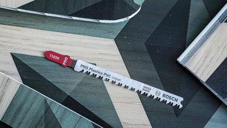 Overhead view of a Bosch T102H jigsaw blade resting on a patterned vinyl or laminate surface.