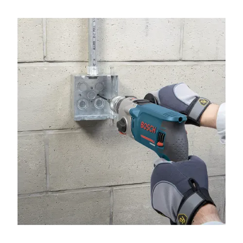 An action application shot displaying the preliminary phase of masonry anchoring where a technician uses a corded Bosch hammer drill tool to bore a precision pilot hole into a concrete block background. The user guides the specialized masonry bit from the TCHC9 kit directly into marked guidelines on the wall to ensure a perfectly clean and straight anchoring socket.