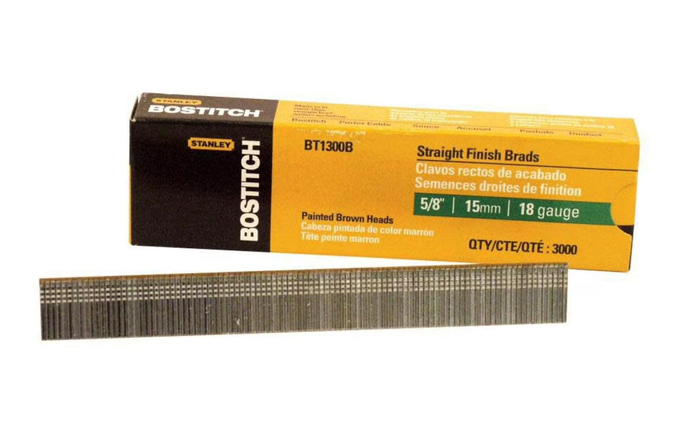 The image shows a strip of Bostitch Stanley BT1300B 5/8" brad nails, which are thin metal fasteners used in woodworking. The nails are arranged in a row and held together by a strip of material. The box they come in is yellow and black with the Bostitch and Stanley logos on it. The text on the box indicates they are 5/8 inch long and 18 gauge.
