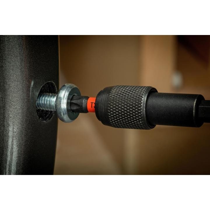 Close-up action shot of a magnetic bit holder gripping the T30 bit while driving a silver washer-head screw into a dark fixture.