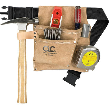 A lifestyle product photograph showing the CLC suede leather nail bag in use, organized with a hammer in the side loop, a tape measure on the dedicated strap, and various fasteners, a level, and a screwdriver in the reinforced pockets.