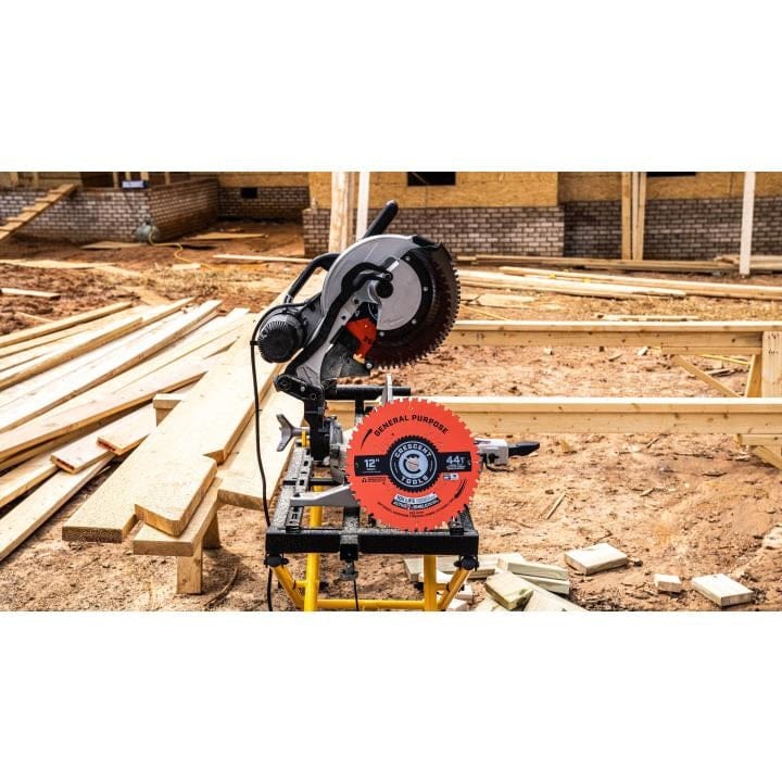A Crescent circular saw blade (44T model) mounted on a miter saw at a dusty construction site with wood framing and dirt ground in the background.