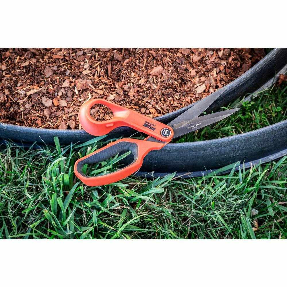 The Crescent Wiss CW10TL 10 inch shears resting on a mulch bed next to landscape edging, highlighting their multi-purpose outdoor utility.