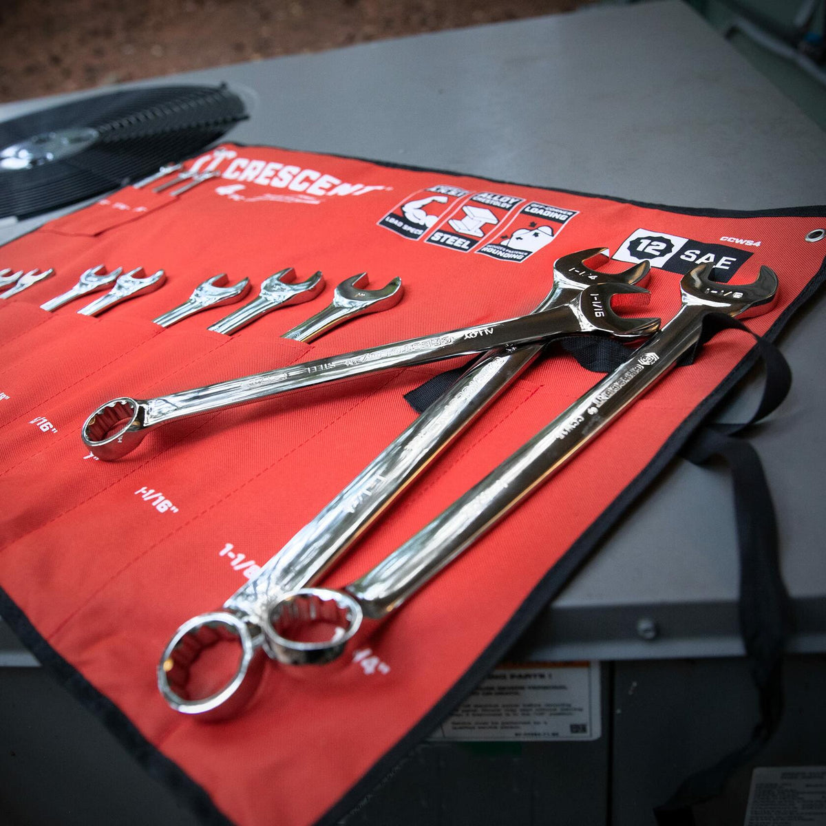 Red Crescent tool roll displaying a full set of SAE combination wrenches. Sizes range from 1/4" to 1", each slot labeled with inch measurements. Branding includes “CRESCENT,” “SAE,” and “12 PT.”