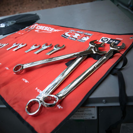 Red Crescent tool roll displaying a set of combination wrenches labeled with the NBA logo and “Official Tool.” Wrenches range from 1/4" to 7/8", each with open-end and box-end sides. Two larger wrenches are placed on top of the roll.