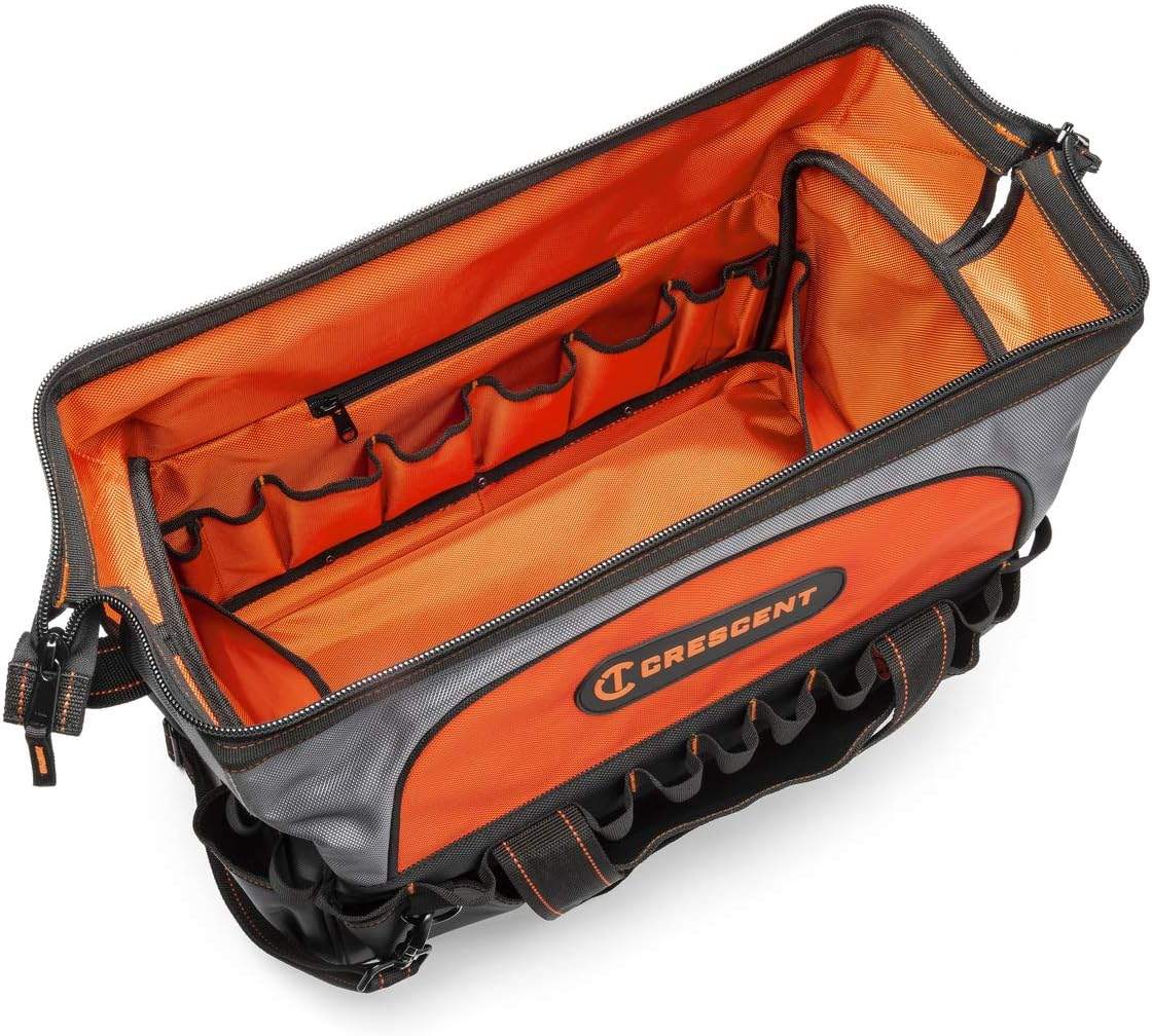 An overhead view of the Crescent 20-inch contractor tool bag opened wide, revealing the bright orange interior fabric, numerous internal pockets, and the black exterior pockets with tool loops.