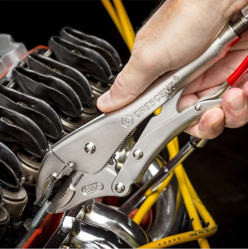 Action shot showing a worker using a Crescent curved jaw locking plier to securely grip a threaded fastener inside a mechanical assembly