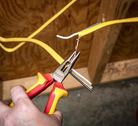 Studio front view of the Crescent 8 inch VDE insulated long nose pliers, showing the long serrated jaws and the red and yellow ergonomic handles