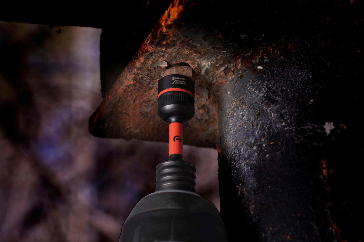 Close-up action shot demonstrating the Crescent APEX Bolt Biter firmly gripping a severely rusted and degraded bolt on a heavy structural steel beam, preparing for impact extraction.
