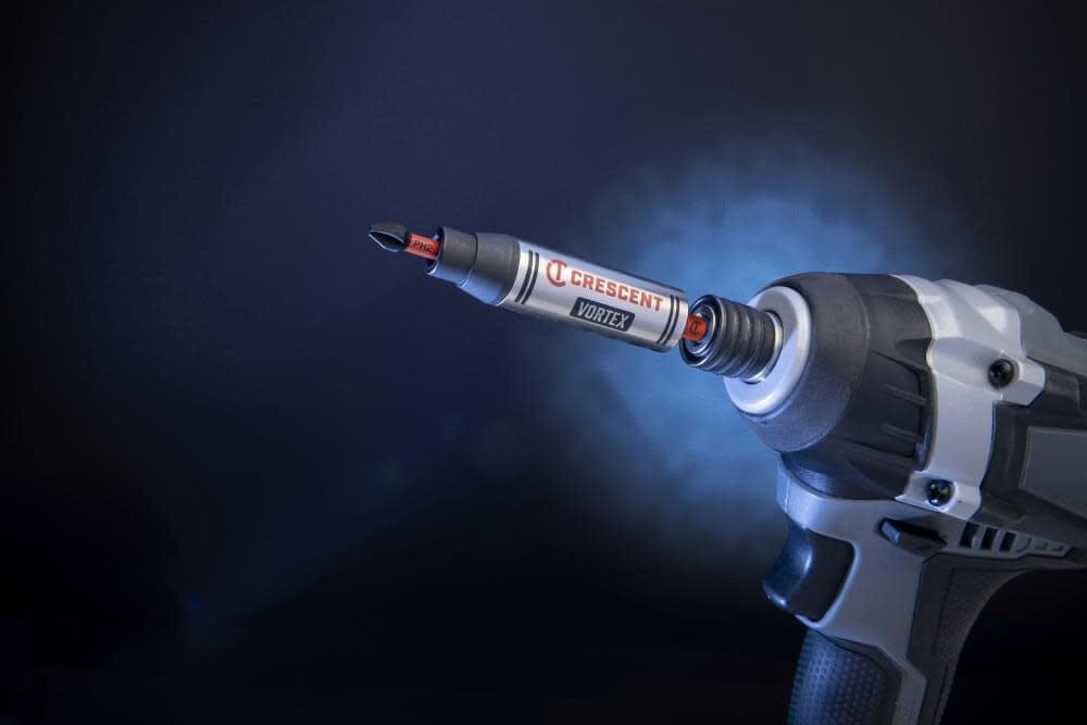 Studio shot of a Crescent APEX Vortex bit holder in an impact driver against a dark blue background with a Phillips bit loaded.