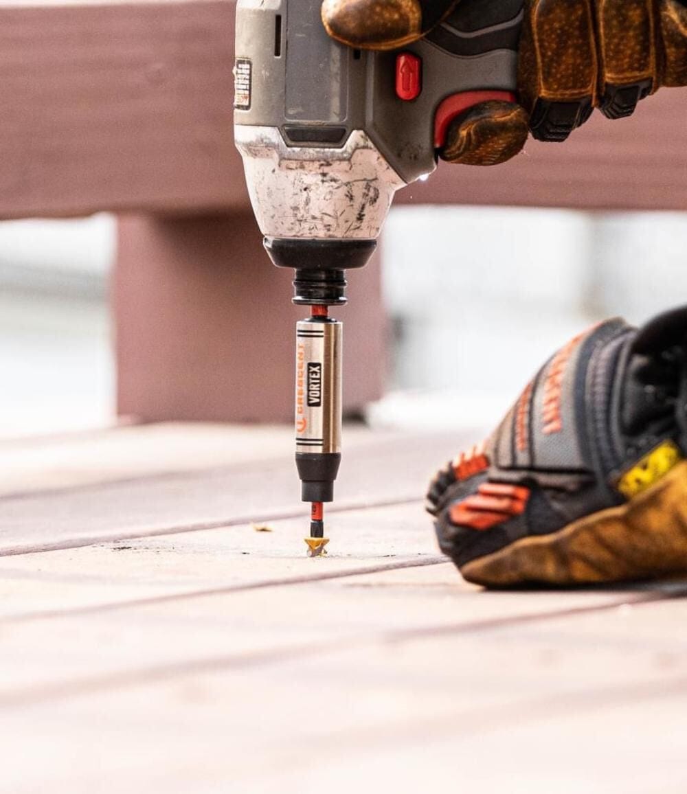 Close-up of a worker using a power tool to drive a screw using a Crescent APEX Vortex bit holder.