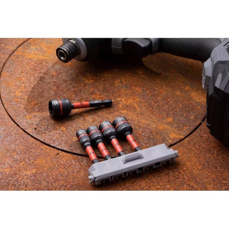 The Crescent Bolt Biter extractor set resting on a rusted metal surface next to an impact driver, demonstrating the tool's specialized use for heavy-duty automotive and industrial repairs.