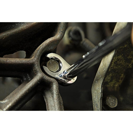 An action photo of a Crescent 6-point flare nut crowfoot wrench being used with an extension to access a recessed hex bolt in a cramped engine compartment, demonstrating the tool's specialized utility in restricted spaces.