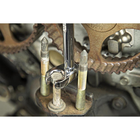 A professional technician using a Crescent CCFWS0N crowfoot wrench to tighten a bolt deep inside a mechanical assembly with tight vertical clearance, showcasing the tool's precision fit and mirror-like chrome finish.