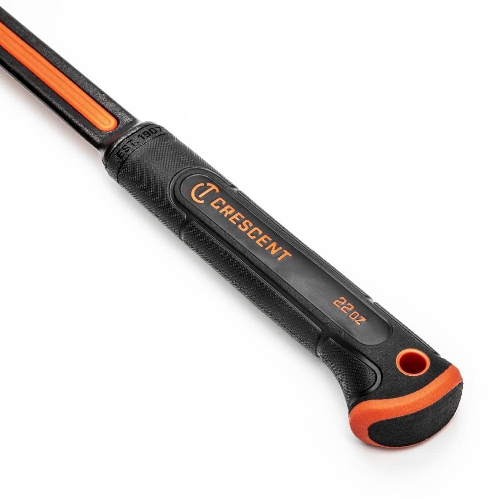 Close-up of the textured ergonomic handle grip on the Crescent all-steel hammer, showing the recessed tether point for safety and the 22 oz weight specification.