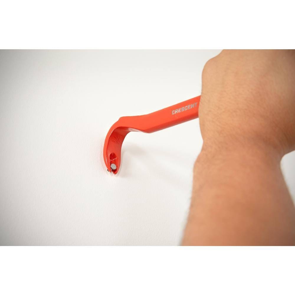 Close up action shot of a worker using the rocker head of the Crescent CNP12 pry bar demolition tool to gain maximum leverage while pulling a stubborn nail from a wall.