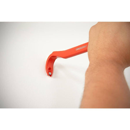 Close up action shot of a worker using the rocker head of the Crescent CNP12 pry bar demolition tool to gain maximum leverage while pulling a stubborn nail from a wall.