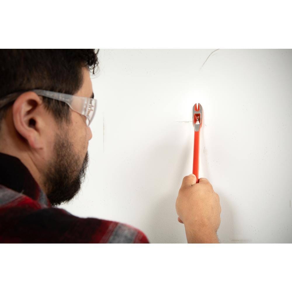 Construction worker wearing safety glasses using the Crescent 12-inch double end nail puller and pry bar to precisely extract a fastener during an indoor renovation project.