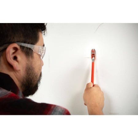 Construction worker wearing safety glasses using the Crescent 12-inch double end nail puller and pry bar to precisely extract a fastener during an indoor renovation project.