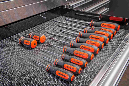 Lifestyle shot showing the complete screwdriver set neatly organized within a drawer of a metal tool chest on a black non-slip liner.