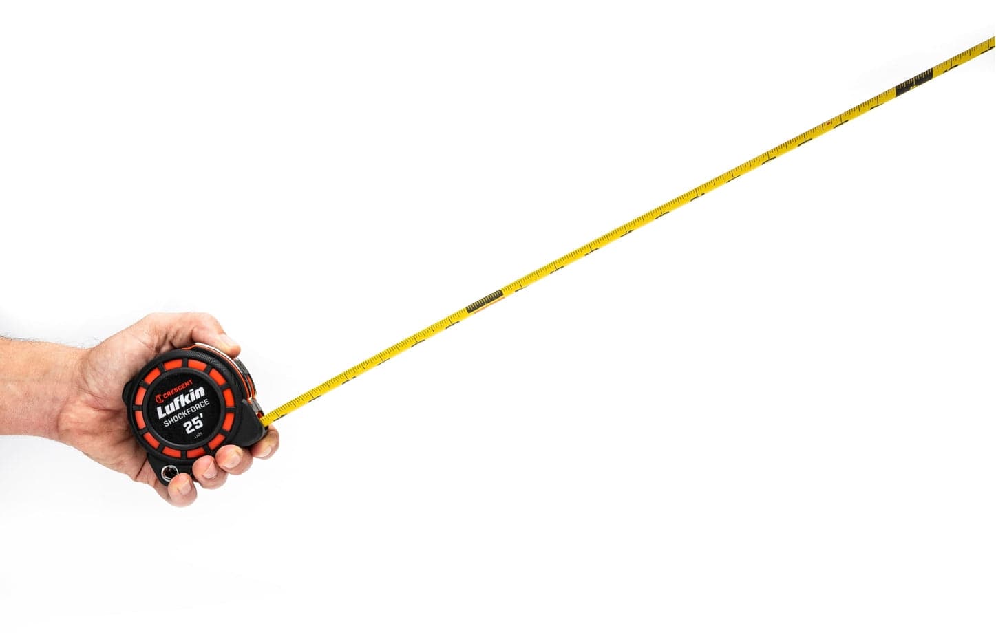 A person holding the compact Crescent Shockforce tape measure with the blade extended horizontally, demonstrating the high-performance blade standout and narrow blade technology for reduced weight.
