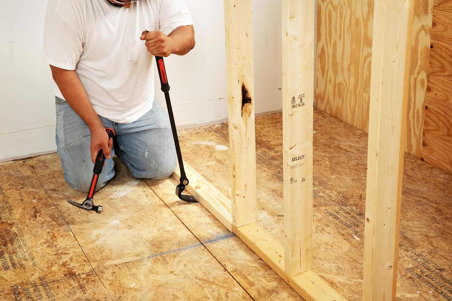 Construction professional using the adjustable head of the Crescent indexing pry bar to pry a bottom plate wall stud away from a wood floor.