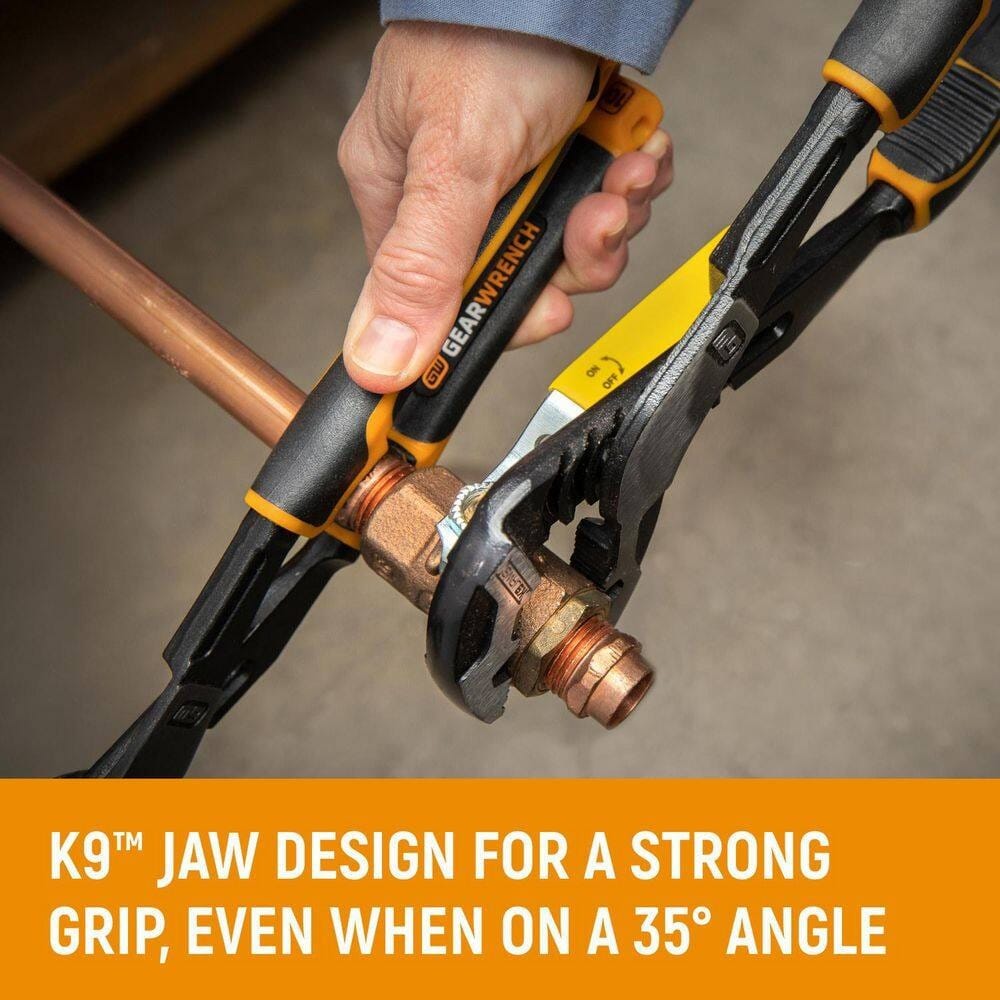 An action shot demonstrating the GearWrench PITBULL K9 pliers tightening a brass pipe fitting, showcasing the tool's ability to maintain a strong, non-slip grip at an aggressive angle.