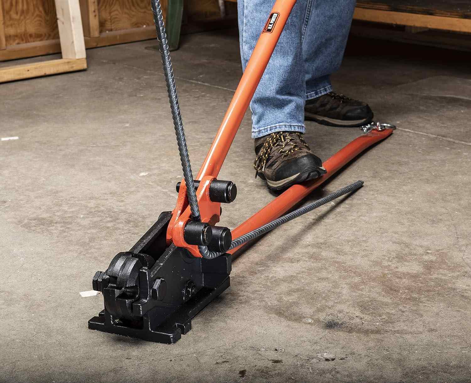 An action shot from a different angle, showing a worker bending a piece of rebar to a 90-degree angle with the H.K. Porter 0590RBJN.