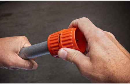 Tradesman demonstrating manual deburring on metal conduit using the Crescent inner and outer pipe reamer tool.