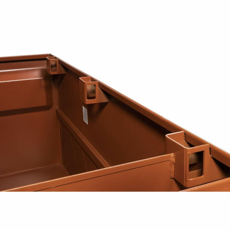 Interior corner of a brown steel Crescent JOBOX storage chest showing reinforced edges and square mounting brackets. Welded seams and smooth finish highlight the industrial-grade construction designed for secure jobsite storage.