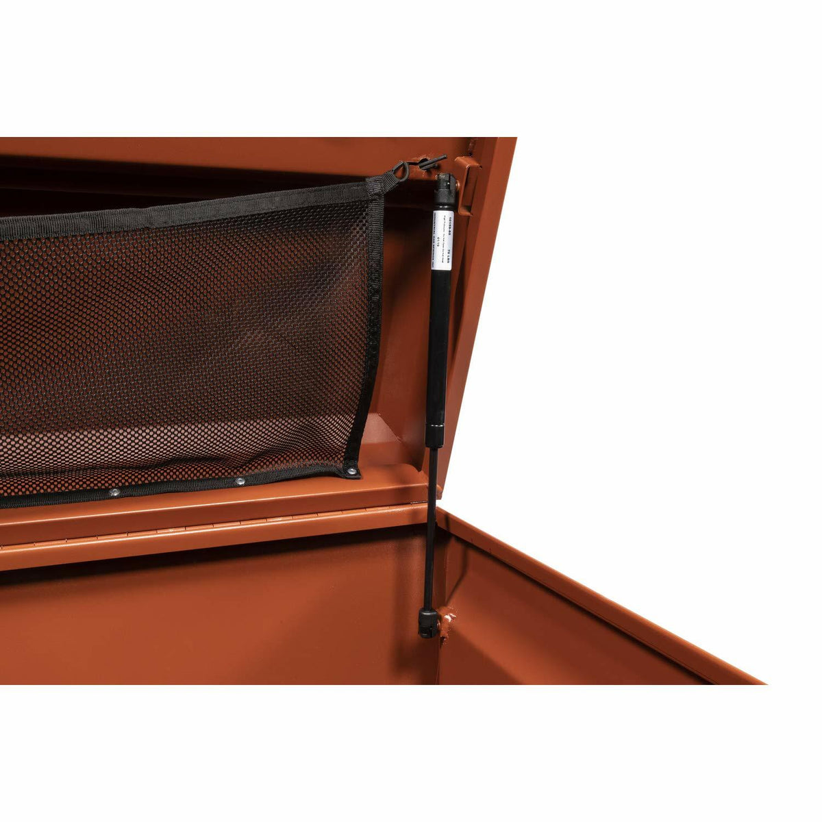 Inside corner of Crescent JOBOX chest with open lid showing vertical gas strut and mesh pocket. Reinforced construction and support mechanism designed for secure and organized jobsite storage.
