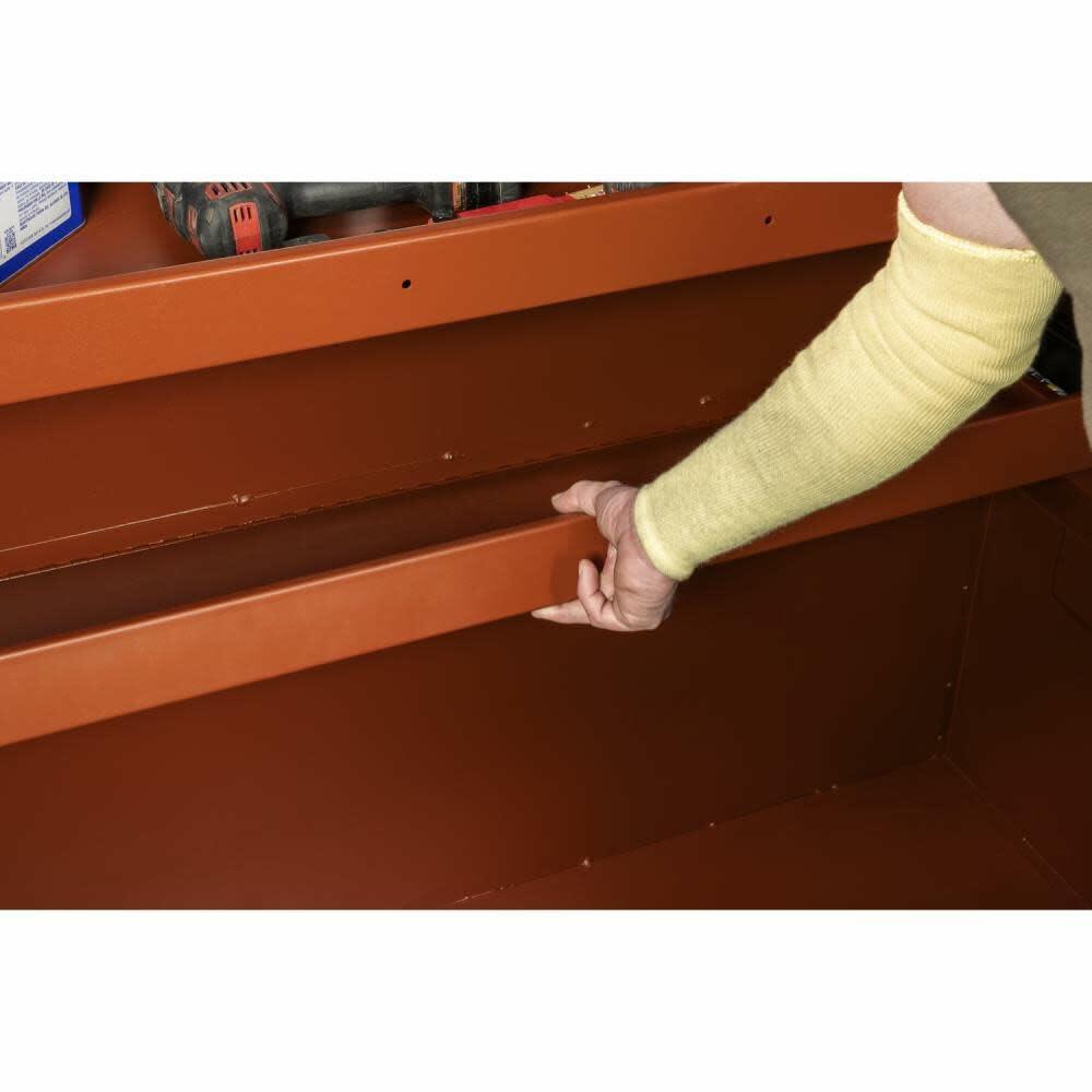 Person adjusting a metal shelf on a wooden surface