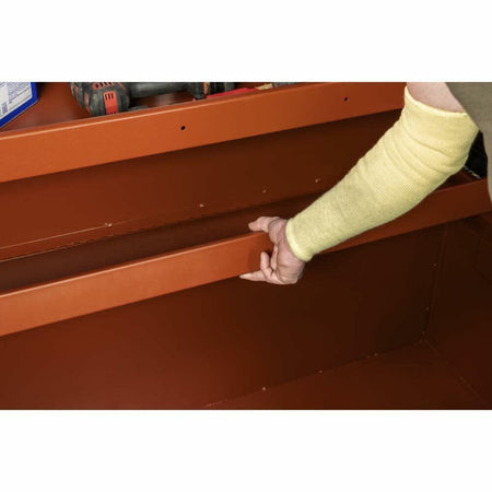 Person adjusting a metal shelf on a wooden surface