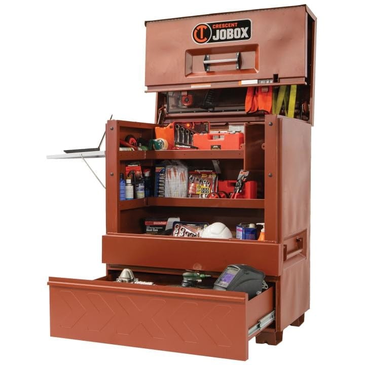 Crescent JOBOX 48-inch Site-Vault heavy-duty piano box jobsite storage cabinet, open and filled with various tools, supplies, and a laptop on the side shelf. The bottom drawer is extended.