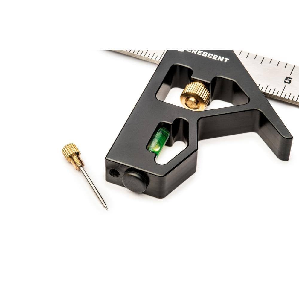Close-up detail of the square head with the hardened brass scribe removed from its storage slot and resting next to the integrated green spirit level bubble.