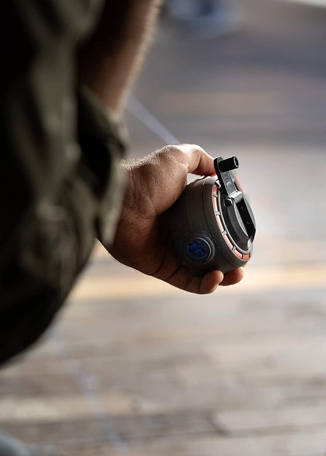 User holding the Crescent Lufkin contractor chalk reel and preparing to snap a precise layout line on a wooden floor surface.