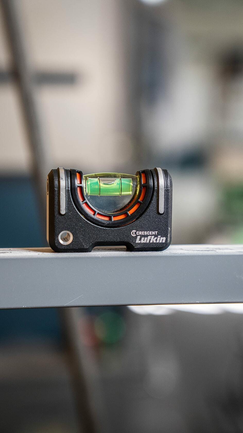 The Crescent Lufkin pocket level is shown resting horizontally on a gray metal beam, with the magnified vial bubble centered.