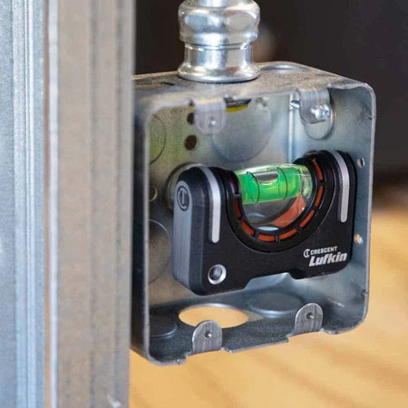 The Crescent Lufkin pocket level is shown magnetically attached inside a metal electrical junction box to ensure it is level.