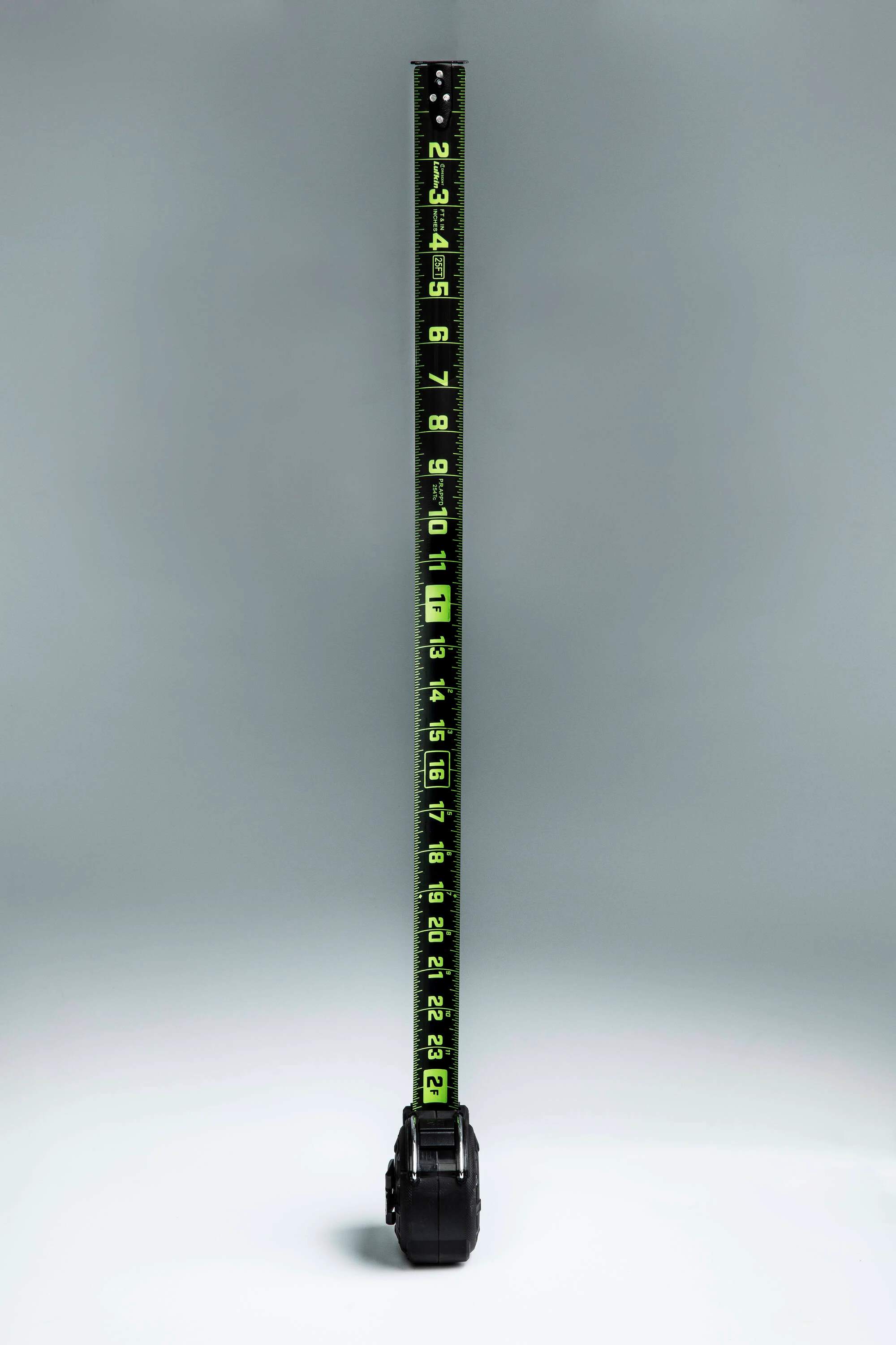 Vertical view of the fully extended Crescent Lufkin 35-foot Nite Eye blade, highlighting the high-visibility neon green markings against the matte black steel surface.
