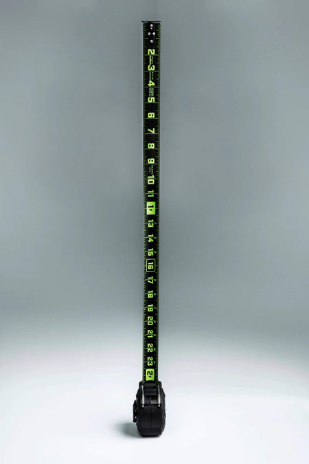 Vertical view of the fully extended Crescent Lufkin 35-foot Nite Eye blade, highlighting the high-visibility neon green markings against the matte black steel surface.