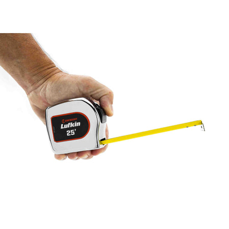 A user holding the Crescent Lufkin L925-02 tape measure in one hand with the matte nylon coated blade extended, illustrating the compact ergonomic design for site work.