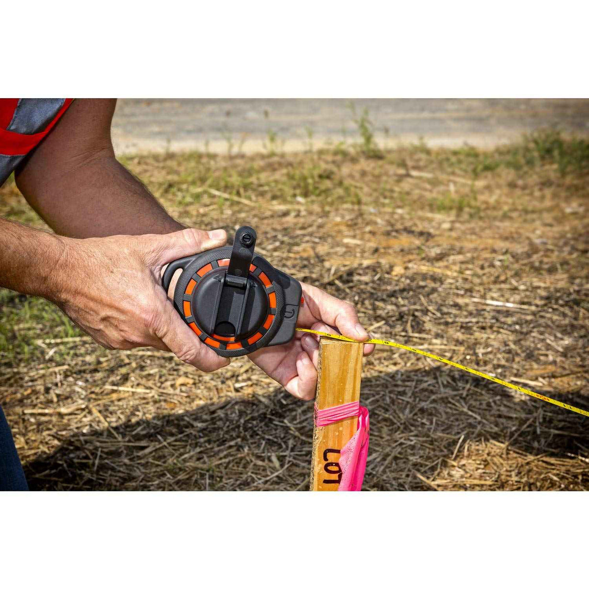 A detailed view of the Crescent Lufkin ST50-07 case being held by a professional, demonstrating the compact ergonomic design and the seated rewind handle that protects the crank assembly during storage.